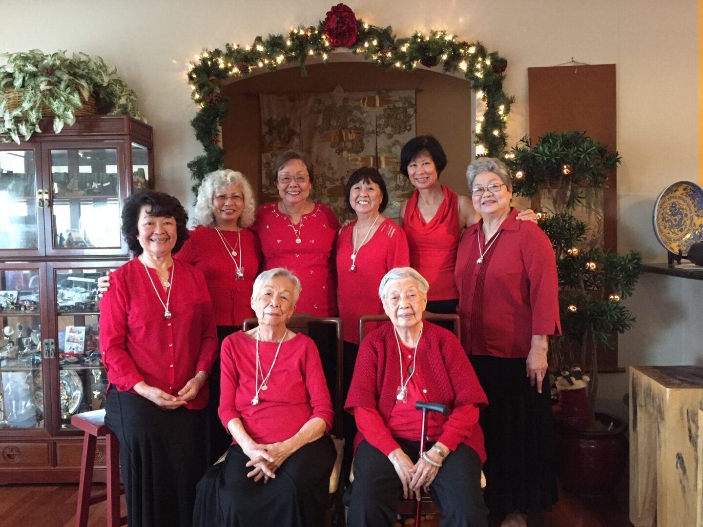 Group of women in red smiling by garland